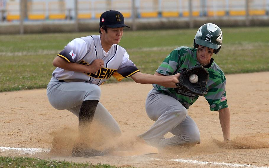 Kubasaki's Ryder Beaudoini slides safely into third base just ahead of the tag by Kayden Connolly during Wednesday's Okinawa baseball game. The Dragons won 8-5.