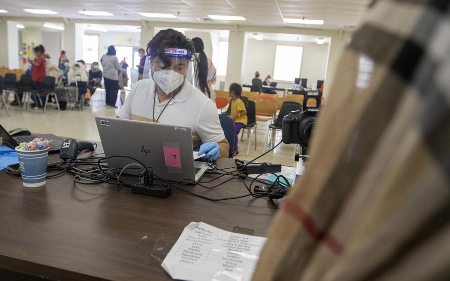 Jose Camarillo, an immigration service officer for Department of Homeland Security assigned to Task Force McCoy, reviews paperwork from an Afghan evacuee before starting the biometrics process Sept. 6, 2021, at Fort McCoy, Wis.