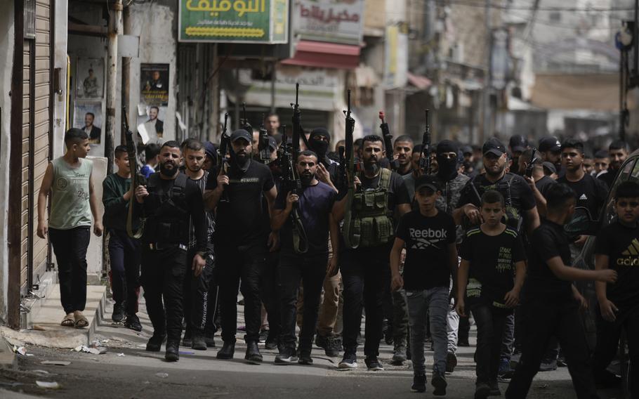 Palestinian gunmen march during the funeral of three Palestinian militants, Abdullah Abu Hamdan, 24, Muhammad Zaytoun, 32, and Fathi Rizk, 30, in the Balata refugee camp near the West Bank town of Nablus on Monday, May 22, 2023. 