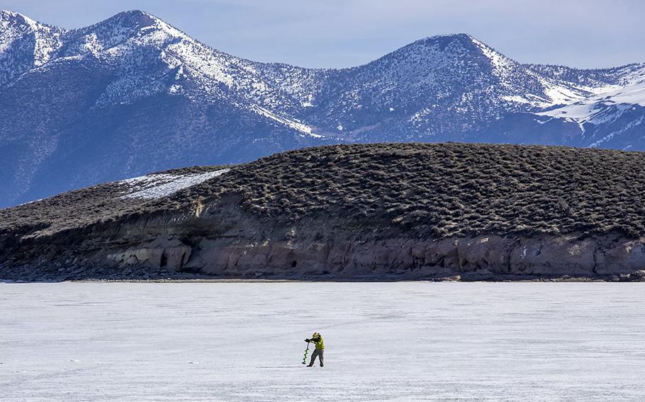 A fisherman augers in on a frozen Crowley Lake on the official opening day of trout season. Ice fishing was the only option on the lake as the marina was still frozen.