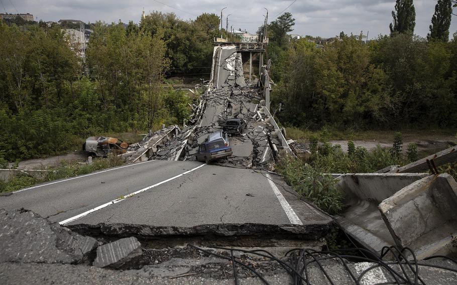 Vehicles are seen on and around a damaged bridge in Kupiansk, Ukraine, on Sept. 16, 2022. Ukraine’s surprise counteroffensive in the Kharkiv Oblast forced Russian forces to retreat from Kupiansk and other key cities in the region. 