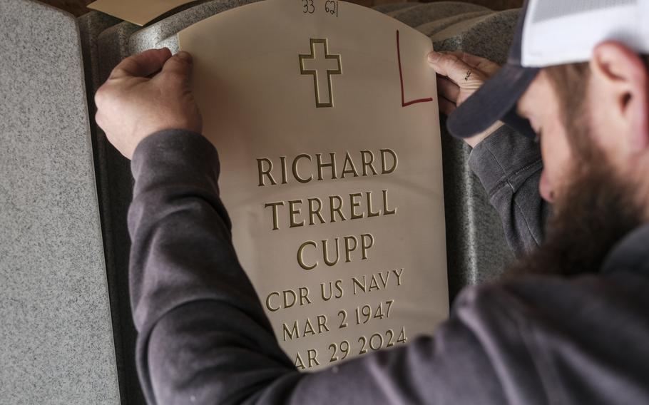 Adam Johnson prepares a headstone at the National Memorial Cemetery at Quantico in Triangle, Va. 