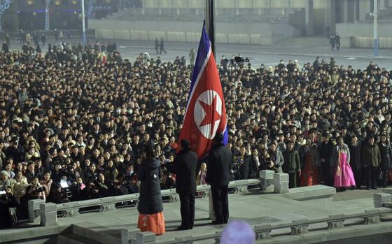 North Koreans hoist their flag during a celebration marking the new year on Jan. 1, 2024. 
