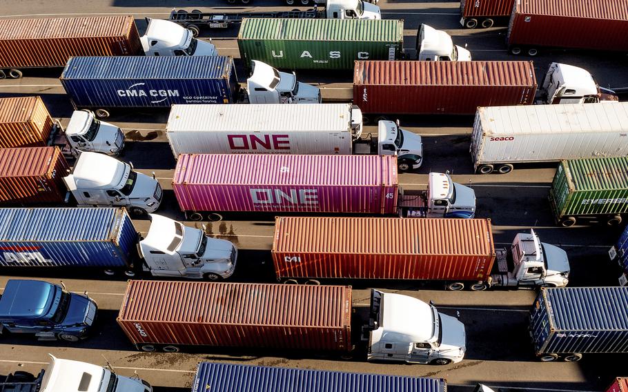 Trucks line up to enter a Port of Oakland shipping terminal on Nov. 10, 2021, in Oakland, Calif. The pandemic has receded as a top priority in many voters’ minds to start 2022, with the economy overshadowing coronavirus concerns and worries about inflation on the rise, a poll from The Associated Press-NORC Center for Public Affairs Research finds.