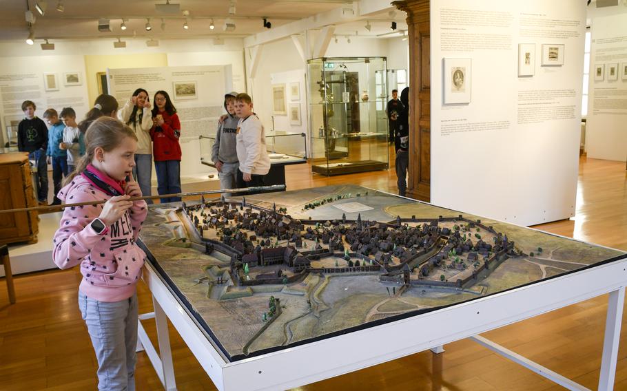 A child on a school trip looks over a diorama of historical Kaiserslautern at the Theodor Zink Museum.