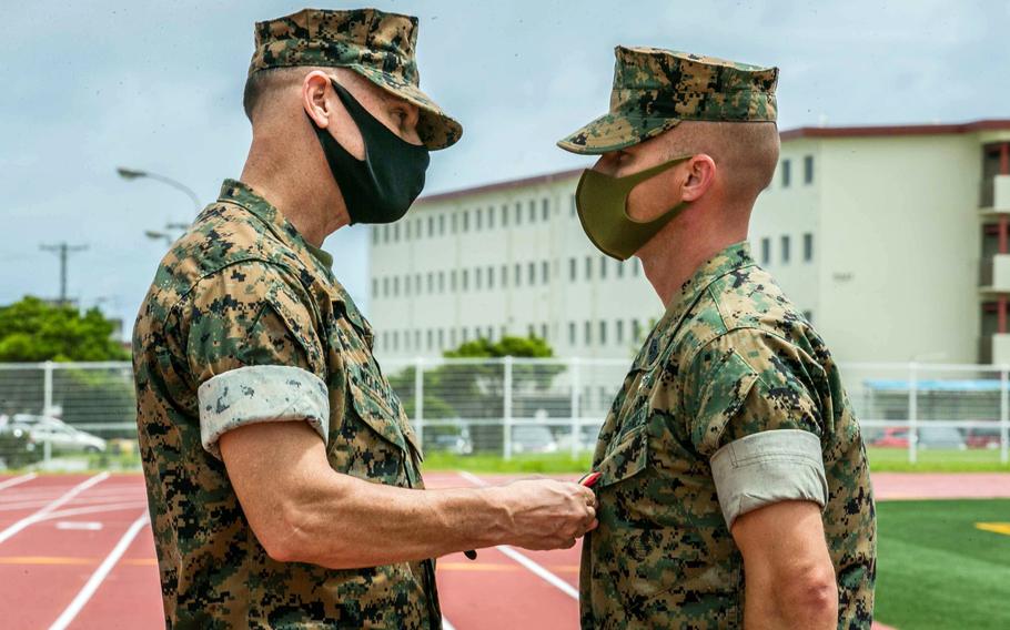 Brig. Gen. Brian Wolford, commander of the 3rd Marine Logistics Group, awards a Navy and Marine Corps Medal to Sgt. Maj. David Potter of the 9th Engineer Support Battalion at Camp Hansen, Okinawa, Aug. 2, 2021. Potter was honored for saving a woman and her child from drowning during a flash flood last year.