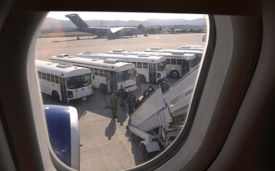 Afghan evacuees board a flight for the United States from Ramstein Air Base, Germany, on Oct. 15, 2021. Thousands have moved on to the U.S. in a little over a week. The last outbound flight was delayed after eight evacuees tested positive for coronavirus during screening.