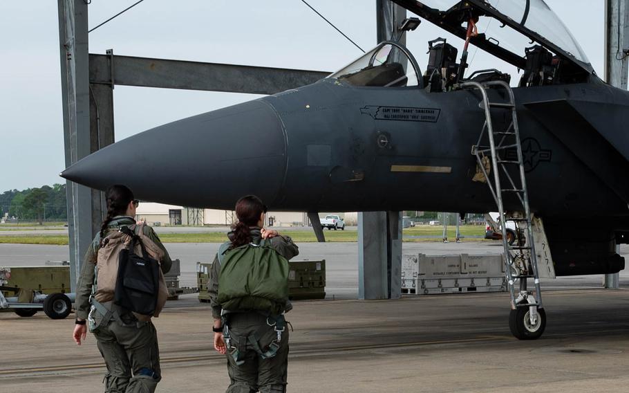 Two women walking toward a jet.