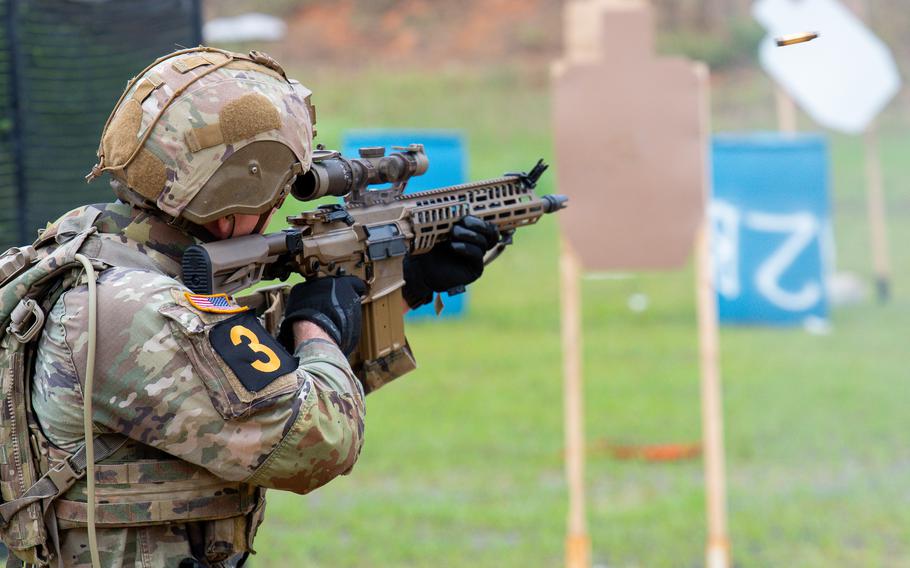 A soldier fire an XM7 carbine at a target