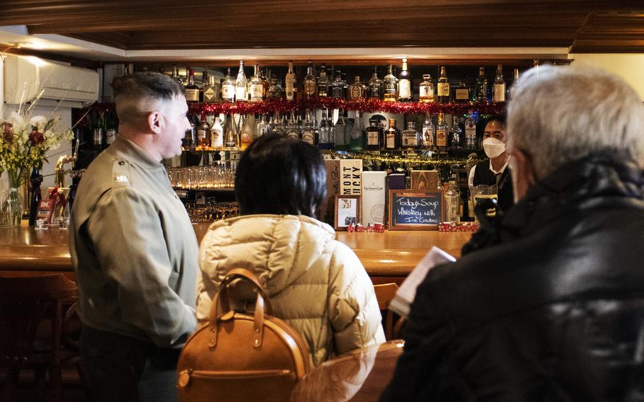 Col. Richard Rusnok, far left, commander of Marine Corps Air Station Iwakuni, Japan, talks with a bar owner during a joint patrol of Iwakuni city, Dec. 8, 2023. 