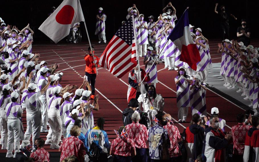 The flags of Japan, the United States and France are carried into National Stadium during closing ceremonies for the Tokyo Paralympics, Sunday, Sept. 5, 2021. 