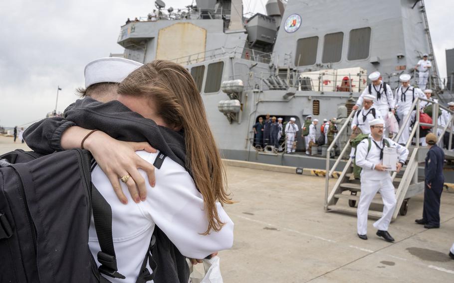 A sailor assigned to the destroyer USS Mitscher embraces his wife after the ship's return to Naval Station Norfolk, Va., April 16, 2022. Mitscher rapidly deployed in January in support of Naval Forces Europe and NATO allies. 