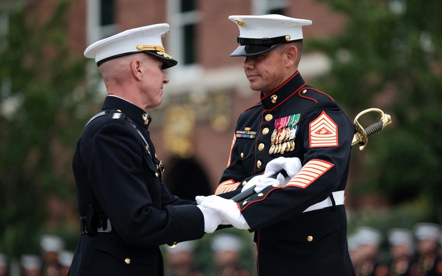 Assistant Commandant of the Marine Corps Gen. Eric M. Smith passes the noncommissioned officer sword to the incoming Sergeant Major of the Marine Corps, Sgt. Maj. Carlos A. Ruiz, during a relief and appointment ceremony at Marine Barracks Washington, Aug. 10, 2023.