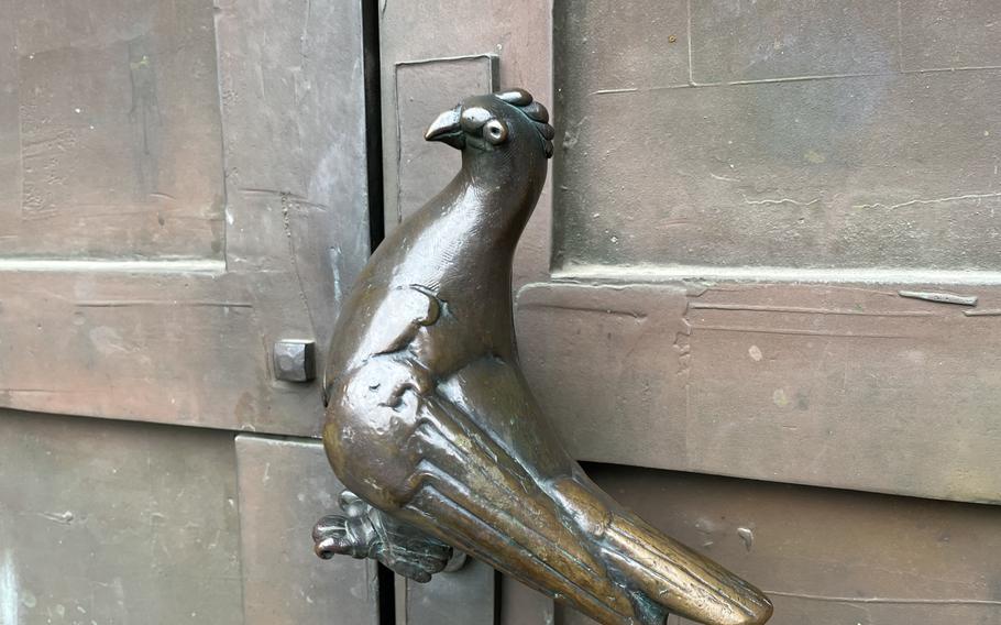 A door handle on a church is shaped like a pigeon.