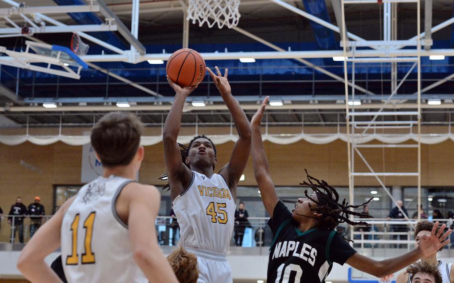 Vicenza’s Joe Kelly aims for the basket against a defending Jeramiah Robinson of Naples  in the boys Division II final at the DODEA-Europe basketball championships in Wiesbaden, Germany, Feb. 17, 2024. Vicenza won the game 76-37.