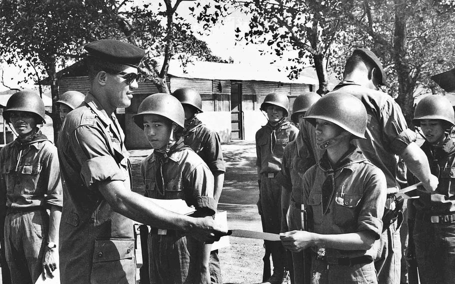 Then-Capt. Paris Davis congratulates a soldier assigned to the 883rd Regional Forces for completing training in Vietnam in 1965. 