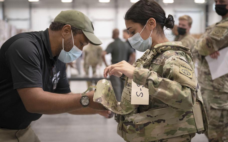 In this image provided by the U.S. Army, Sgt. Katiushka Rivera, a soldier assigned to the 82nd Airborne Division, gets fitted for a modular scalable vest (MSV) during a fielding event in Fort Bragg, N.C., on Sept. 13, 2021.