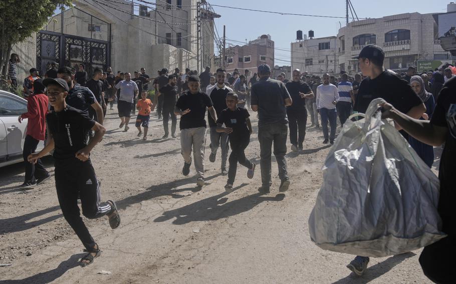 People running and gathering their belongings as their homes are destroyed in a refugee camp in the West Bank.