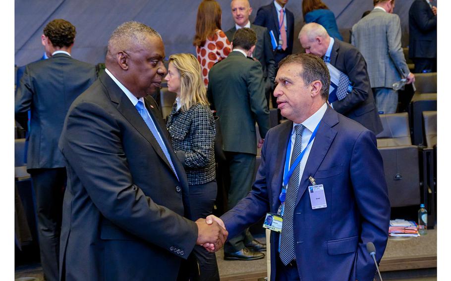 U.S. Defense Secretary Lloyd J. Austin shakes hands with Haim Regev, Israel's ambassador to NATO and the EU, during a meeting of NATO defense ministers in Brussels, Oct. 12, 2023.