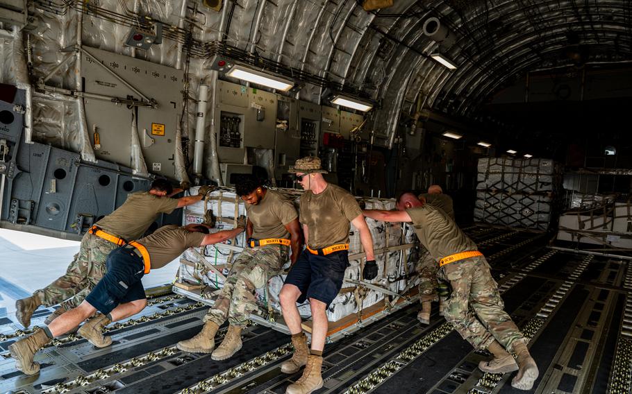 Service members load supplies into a U.S. Air Force C-17A Globemaster III aircraft in support of a humanitarian mission to Pakistan from Al Udeid Air Base, Qatar, Sep. 14, 2022.