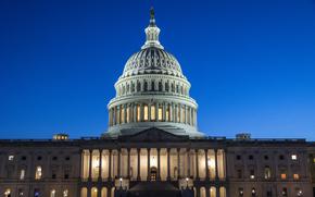 The U.S. Capitol building is illuminated with the night sky behind it.