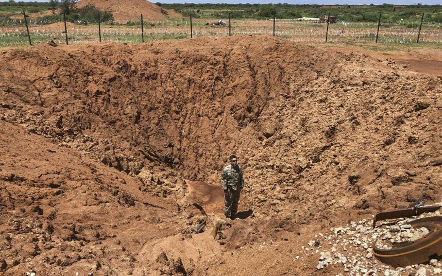 A New Jersey Army National Guard soldier stands in the crater created by a truck bomb explosion in 2019 at Baledogle Military Airfield, Somalia. U.S. Africa Command said July 6, 2023, that no U.S. troops were injured in a blast earlier the same day in Somalia, when a convoy hit an improvised explosive device.