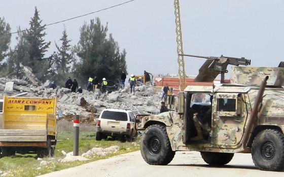 A Lebanese army vehicle block a road leading to a destroyed warehouse, background, which was attacked by Israeli airstrikes, on the outskirts of the Hezbollah stronghold village of Buday, near Baalbek town, east Lebanon, Monday, Feb. 26, 2024. The Israeli military says its air force struck targets of the militant Hezbollah group "deep inside Lebanon," where residents reported explosions near the northeastern city of Baalbek. (AP Photo)