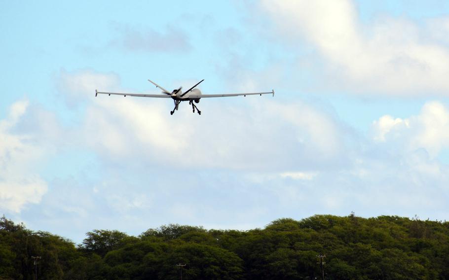 An Air Force MQ-9 Reaper drone flies over the tree line at Marine Corps Base Hawaii during Exercise ACE Reaper, Monday, Sept. 27, 2021. 