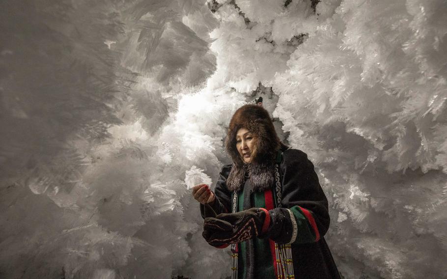 A Yakut guide holds a crystal in a cave dug into the permafrost. 