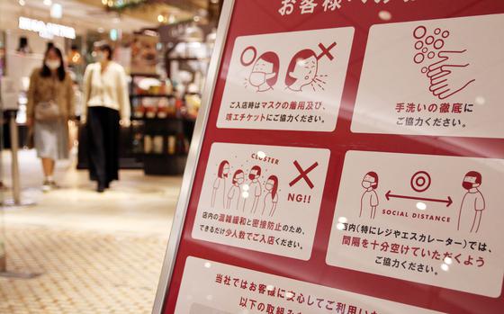 A sign at a shopping area in central Tokyo reminds patrons to wear a mask, wash their hands and follow other anti-coronavirus measures, Tuesday, Nov. 17, 2020. 