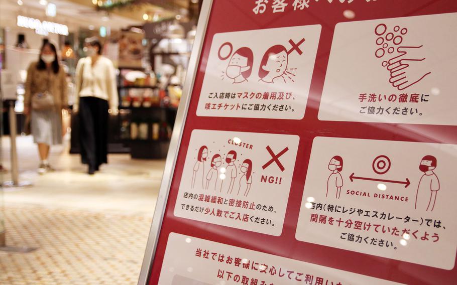 A sign at a shopping area in central Tokyo reminds patrons to follow anti-coronavirus measures, such wearing masks and washing hands, Tuesday, Nov. 17, 2020. 