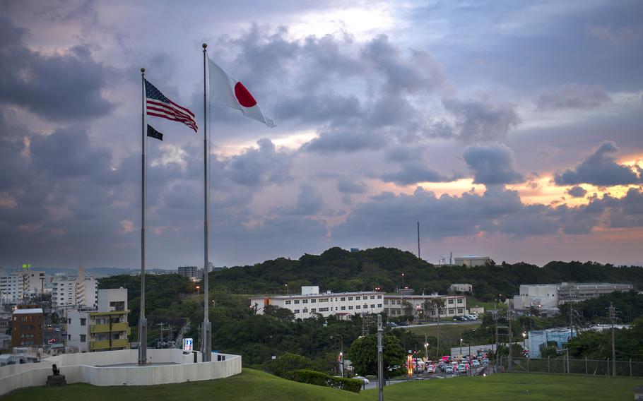 The American and Japanese flags fly at Camp Foster on the Japanese island of Okinawa on July 20, 2023. A workshop to identify impediments to putting more qualified military spouses to work at U.S. Naval Hospital Okinawa and its associated base medical clinics is slated to have about 40 participants.