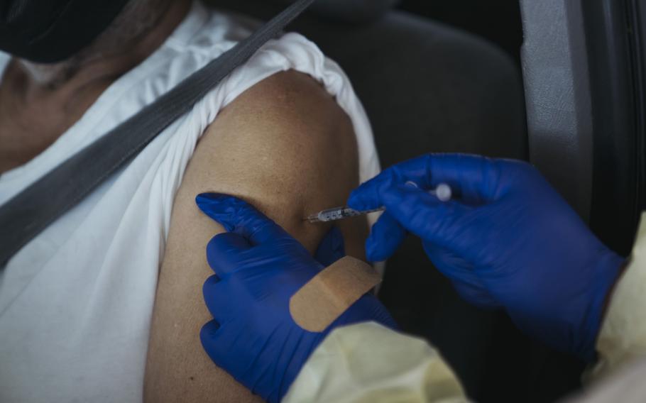 A health care worker administers a dose of the Pfizer-BioNTech Covid-19 Vaccine at a mass vaccination site at The Forum arena in Inglewood, Calif., on Feb. 26, 2021. The Food and Drug Administration is expected to say this week that people can get coronavirus vaccine booster shots that are different from their initial doses.