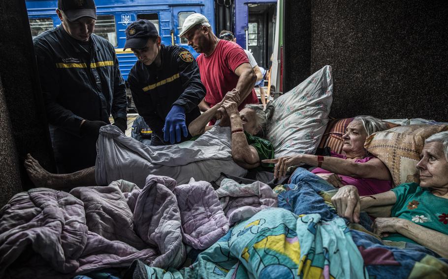 At the train station in Pokrovsk, station employees and volunteers help move Halya, 73, one of four disabled elderly women who lay crammed side-by-side in the back of a van. 