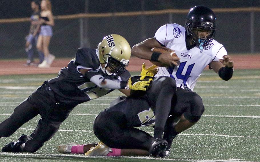 Osan's Jaylon Grant tries to shake off the tackle of Humphreys' Christian Whiting and Tyler Wilks.