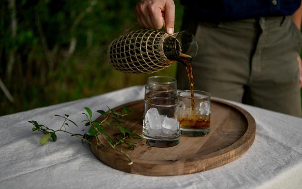 A woman pours a cup of yaupon.