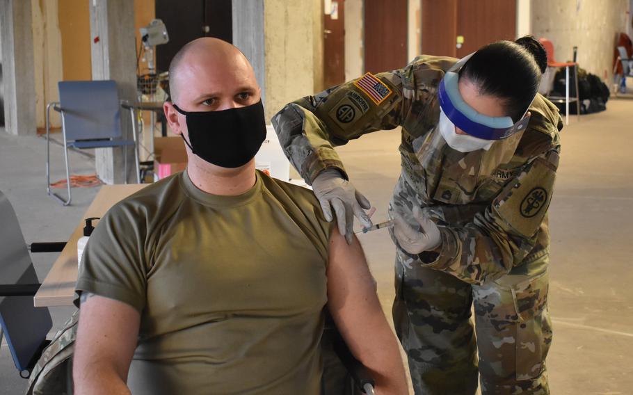 Sgt. Andrew Petersen, left, biomedical equipment technician at SHAPE Healthcare Facility, receives a coronavirus vaccination at the health care facility Jan. 8, 2021, at Mons, Belgium. 