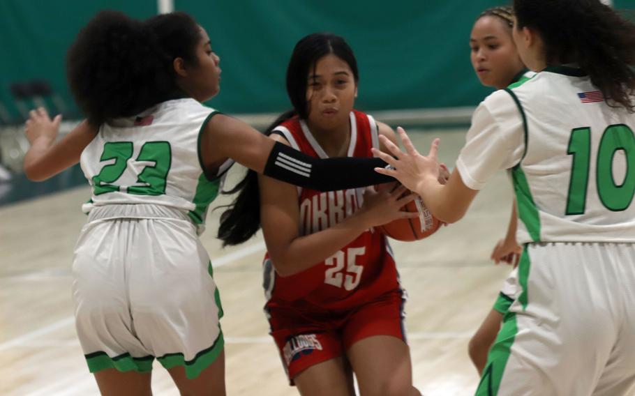 Okkodo's Hanna Neinik tries to drive between Kubasaki's Kadence Johnson and Sophie Grubbs during Monday's Far East Girls Division I round-robin game, won by the Bulldogs 29-26.