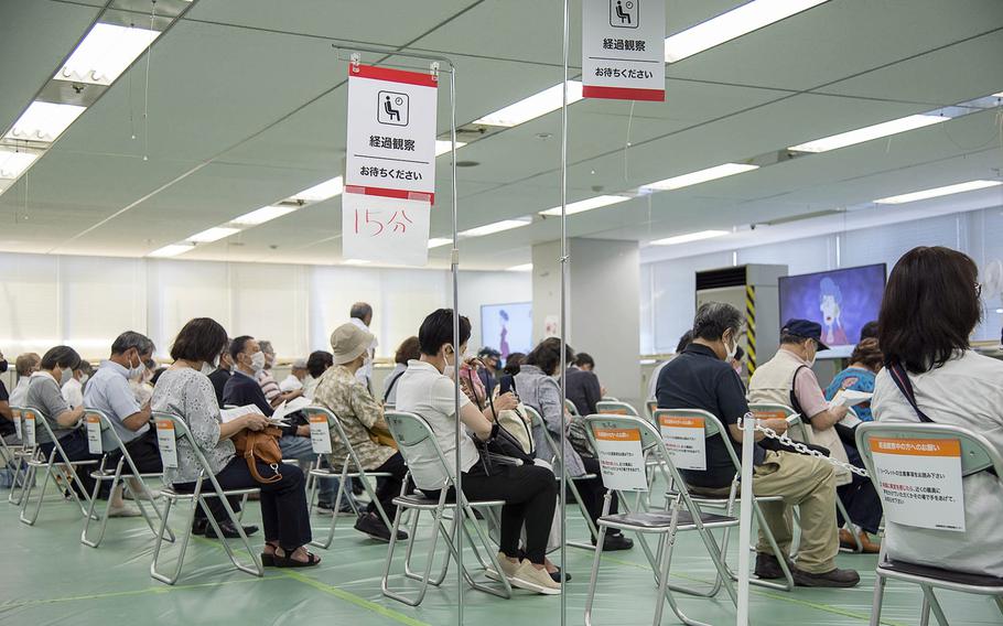 People wait for 15 minutes after receiving the Moderna COVID-19 vaccine during a shot clinic hosted by the Japan Ground Self-Defense Force in Otemachi, Tokyo, Wednesday, June 9, 2021.