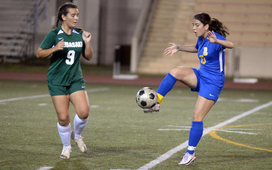 Yokota's Keiya Carlson boots the ball against Kubasaki's Ally Garcia during Saturday's All-DODEA-Japan girls soccer tournament final. The Dragons won 4-1.