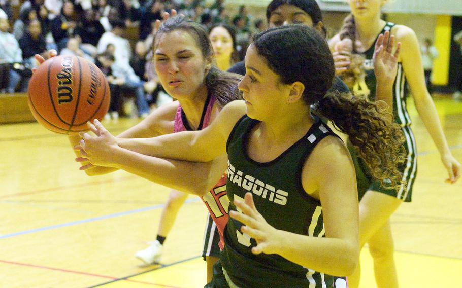 Kadena's Katelyn Wetherington and Kubasaki's Amaya Schaffeld battle for the ball during Friday's Okinawa girls basketball game. The Dragons won 28-24, giving them a 3-1 season-series edge over the Panthers, their first in 20 seasons.