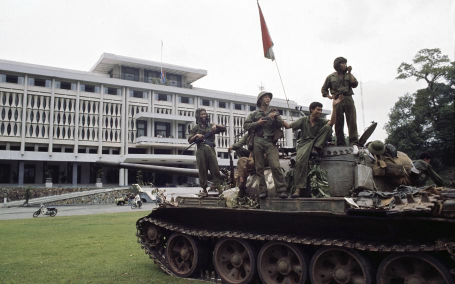 Victorious North Vietnamese troops aboard a tank take a position outside Independence Palace in Saigon.
