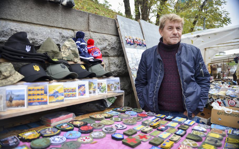 Sergiy Zhornavoy sells unit patches and other wartime memorabilia at his souvenir cart on Volodymyrska Street, one of the oldest boulevards in Kyiv, Ukraine, on Oct. 27, 2022. The vendors, who have sold tchotchkes and trinkets on their street for decades, said their most popular items now are related to the Ukrainian military.