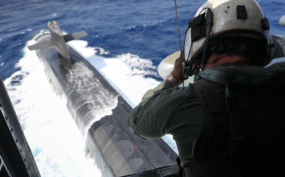 Aboard a CH-53E Super Stallion, Staff Sgt. Joseph McDonnell, a crew chief with Marine Heavy Helicopter Squadron 462, lowers supplies to the Ohio-class ballistic missile submarine USS Maine in the Philippine Sea, May 9, 2023. 
