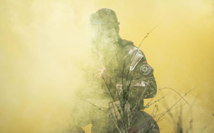 A soldier in a gas mask partially shrouded in yellow smoke.