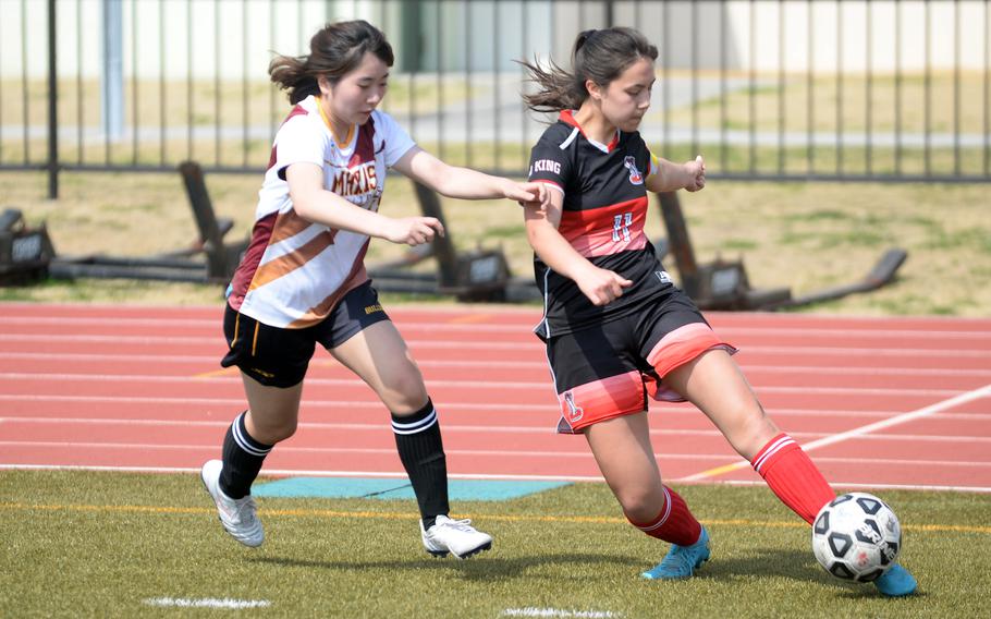 E.J. King’s Maliwan Schinker tries to kick the ball toward field center against Marist Brothers’ Riko Noda.