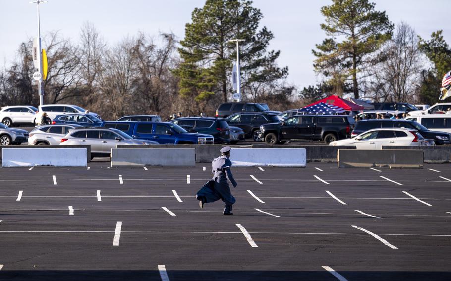 A cadet sprints through the parking lot.
