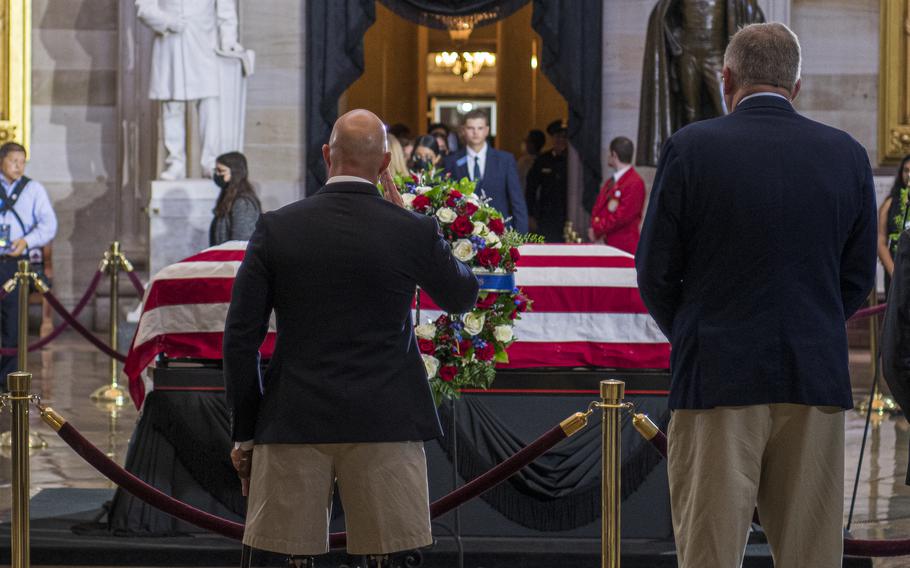 At left, U.S. Rep Brian mast, R-Mich., a double amputee Army veteran, salutes as he pays his respects before the casket of World War II Medal of Honor recipient Hershel Woodrow "Woody" Williams, who was lying in honor at the U.S. Capitol in Washington, on July 14, 2022.