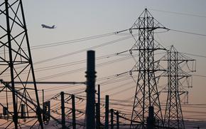 An aircraft takes off from Los Angeles International Airport (LAX) behind electric power lines at sunset as the California Independent System Operator announced a statewide electricity Flex Alert urging conservation to avoid blackouts in El Segundo, California on Aug. 31, 2022. (Patrick T. Fallon/AFP/Getty Images/TNS)