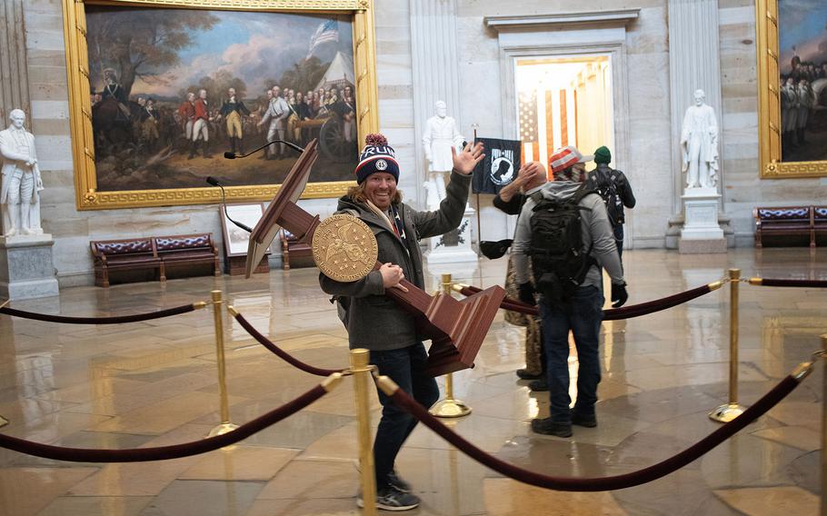 Adam Johnson carries the lectern of U.S. Speaker of the House Nancy Pelosi through the Rotunda of the U.S. Capitol in Washington, D.C. , during the Jan. 6, 2021, riot. Johnson, who was sentenced to 75 days in prison for his part in the riot, had planned a celebratory going away event in his honor, but a Florida restaurant where the gathering was to take place canceled the April engagement when they learned of its purpose.